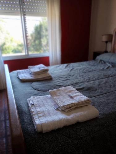 a bedroom with two towels on a bed with a window at Alquileres Viviana in Tandil