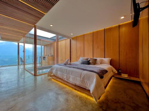 a bedroom with a large bed with wooden walls at Deluxe volcán Primeras suites colgantes del mundo in Baños