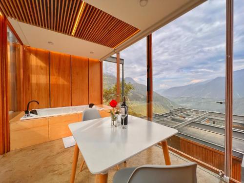a kitchen with a white table and a large window at Deluxe volcán Primeras suites colgantes del mundo in Baños