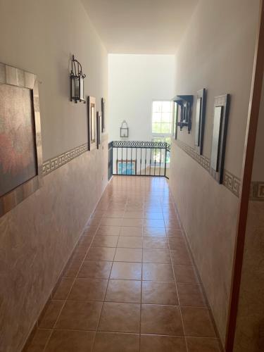 um corredor com piso em azulejo e quadros nas paredes em Hotel Restaurante Azabache em Arboleas