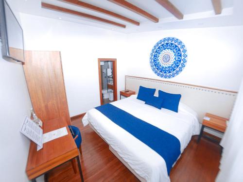 a bedroom with a bed with blue and white sheets at Sangay Spa Hotel in Baños