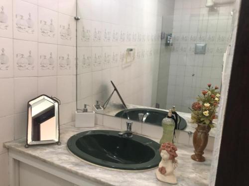 uma casa de banho com um lavatório verde e um espelho em Suites Bouganville ( casa 2) em Porto de Galinhas