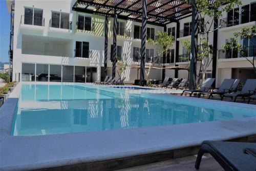 a swimming pool in front of a building at Steps from the Beach Condo Life Bucerias Golden Zone in Bucerías