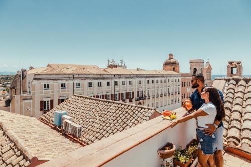 a man and woman standing on top of a roof at Residenza Kastrum in Cagliari