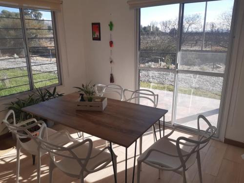 Casas de Cafayate في كفايات: طاولة وكراسي في غرفة بها نوافذ
