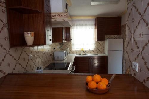 a kitchen with a bowl of oranges on a table at Apartamentos Os Descobrimentos in Burgau