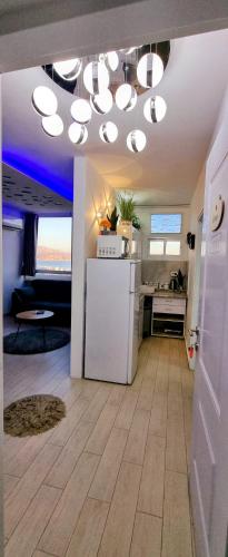 een keuken met een witte koelkast en wat lampen bij Venus Eilat in Eilat