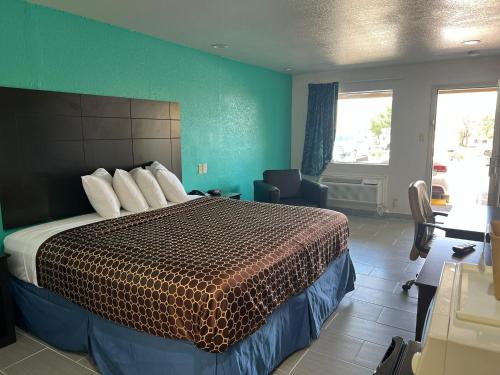 una camera d'albergo con letto e parete verde di Country Hill Inn & Suite Eagle Pass a Eagle Pass