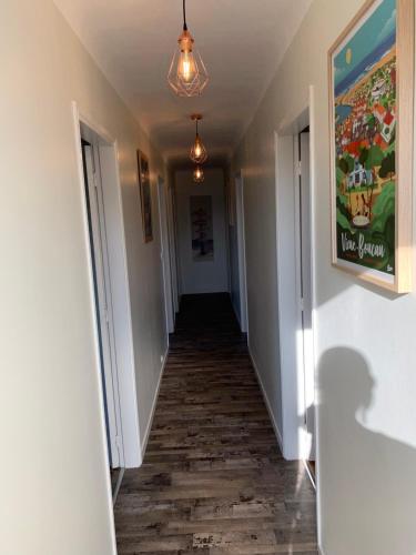 - un couloir avec un long hall revêtu de parquet dans l'établissement Résidence « les Gets » Location T4 Vieux-Boucau-Les-Bains, à Vieux-Boucau-les-Bains
