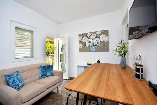 a living room with a couch and a wooden table at Apartment 'MIMO' in Milna - Hvar in Milna