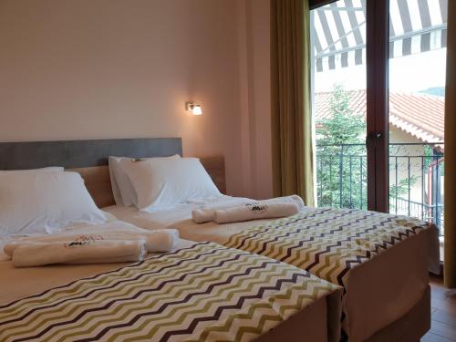 two beds in a hotel room with towels on them at Mondeus Inn Luxury in Deskáti