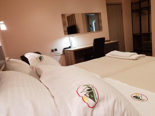 a hotel room with two beds with white pillows at Mondeus Inn Luxury in Deskáti