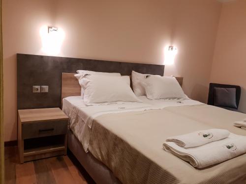 a bedroom with a large bed with two towels on it at Mondeus Inn Luxury in Deskáti