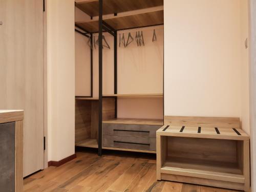 a walk in closet with wooden floors and white walls at Mondeus Inn Luxury in Deskáti