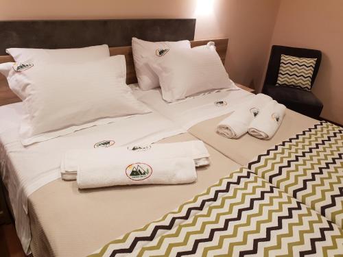 a bed with towels and pillows on it at Mondeus Inn Luxury in Deskáti