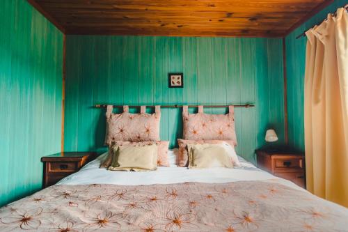 um quarto com uma cama grande e paredes azuis em El Relincho em El Chaltén