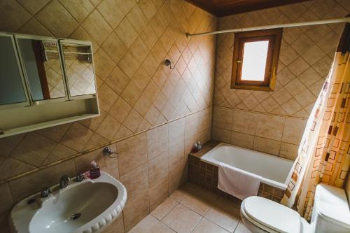 a bathroom with a sink and a tub and a toilet at El Relincho in El Chalten