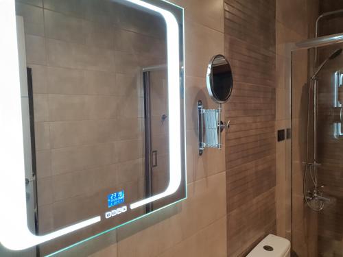 a bathroom with a mirror and a toilet at Mondeus Inn Luxury in Deskáti