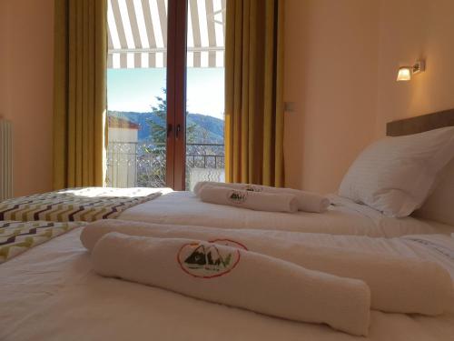 two beds in a hotel room with towels on them at Mondeus Inn Luxury in Deskáti