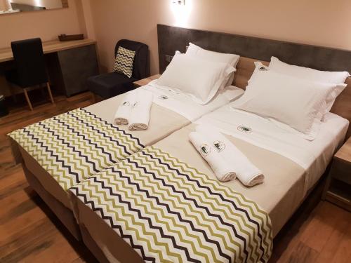a large bed with towels and pillows on it at Mondeus Inn Luxury in Deskáti