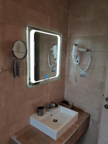 a bathroom with a sink and a mirror at Mondeus Inn Luxury in Deskáti