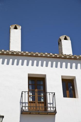 a white building with two windows and a balcony at Villa Turística de Priego in Priego de Córdoba