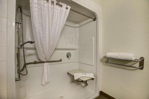 ein Bad mit einer Dusche mit einem weißen Vorhang in der Unterkunft Motel 6-Grande Prairie, AB in Grande Prairie