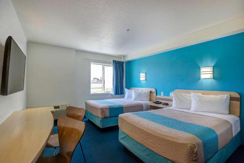 Motel 6-Grande Prairie, AB في غراندي بريري: غرفة فندقية بسريرين ومكتب