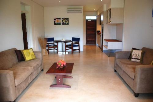 a living room with two couches and a table at Sunset Resort in Rarotonga
