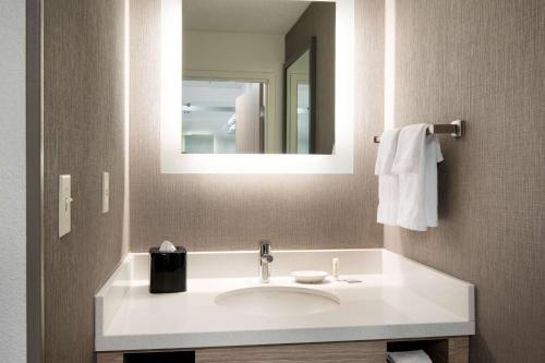 a bathroom with a white sink and a mirror at Sonesta Select Seattle Renton Suites in Renton