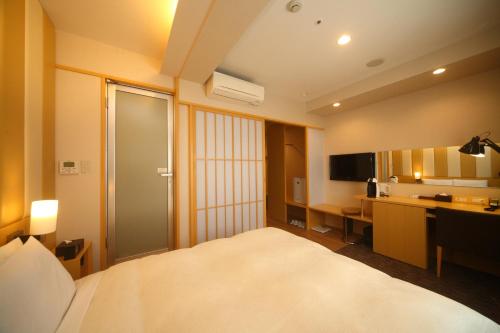 A bed or beds in a room at Hotel Sunroute Kumamoto