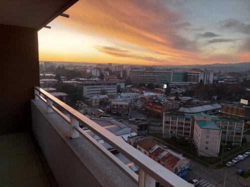 a view of a city at sunset from a balcony at DEPARTAMENTO CENTRO TEMUCO in Temuco
