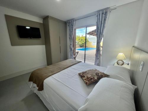 Un dormitorio con una cama grande y una ventana en Sal De Mariscal 10, en Bombinhas