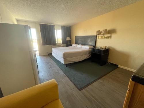 a hotel room with a bed and a couch at Travelodge by Wyndham Imperial - El Centro in El Centro