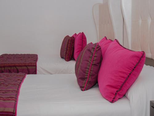 three pink pillows sitting on top of a bed at Sangay Spa Hotel in Baños