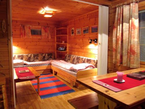 um chalé de madeira com uma secretária, uma mesa e um quarto em Ounasloma Luxury Cottages em Enontekiö
