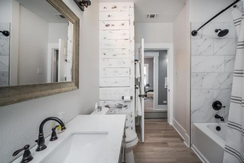 ein Badezimmer mit einem Waschbecken, einem WC und einem Spiegel in der Unterkunft Spacious Home Near Downtown San Antonio in San Antonio