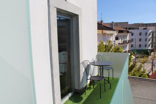 a balcony with a table and chairs and a window at Casa Avé Maria in Fátima