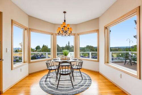 a dining room with a table and chairs and windows at Arrowhead Way in Utsalady