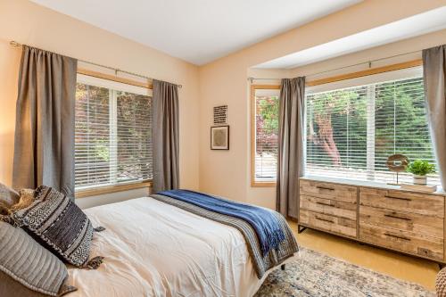 a bedroom with a bed and two windows at Arrowhead Way in Utsalady