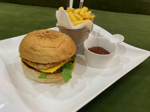 a plate with a hamburger and french fries and sauce at Choice Suites Signature in Ikeja