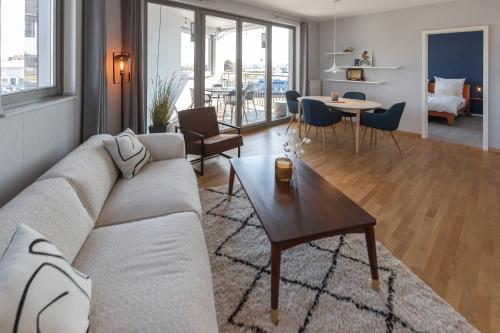 a living room with a couch and a table at Bheaven I Sea Pilot Premium Apartment in Bremerhaven