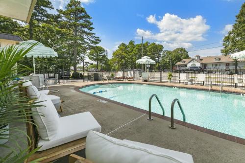 a swimming pool with white lounge chairs next to it at Candlewick Inn and Suites in Eureka Springs