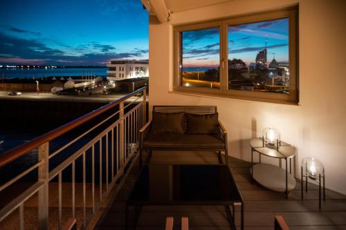 a balcony with a couch and a window at Bheaven I Sea Pilot Premium Apartment in Bremerhaven