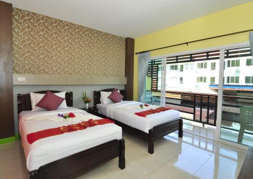 a bedroom with two beds and a balcony at Chongkhao Resort- SHA Certified in Phi Phi Don