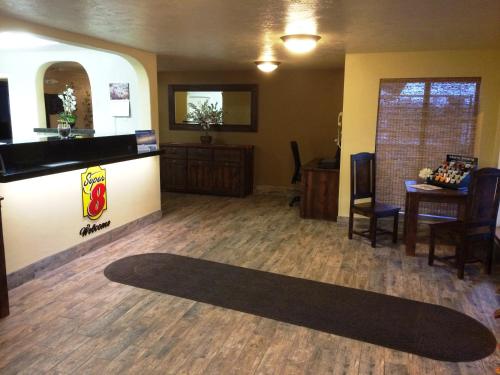 a waiting room with a black rug on the floor at Super 8 by Wyndham Idaho Falls in Idaho Falls