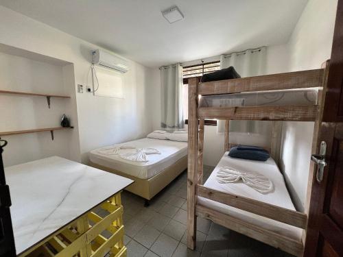 a room with two bunk beds and a table at Chalés Praias Brasileiras in Maragogi