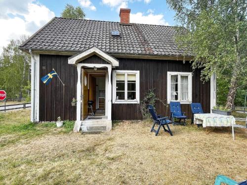 ein kleines Haus mit einem Tisch und Stühlen davor in der Unterkunft 5 person holiday home in LINNERYD KRONOBERGS L N in Linneryd