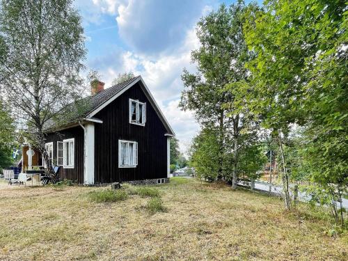 ein schwarzweißes Haus in einem Garten mit Bäumen in der Unterkunft 5 person holiday home in LINNERYD KRONOBERGS L N in Linneryd
