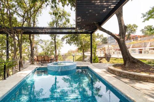 a swimming pool with a tree and a house at Woodland Cabins in Santa Ana Jilotzingo